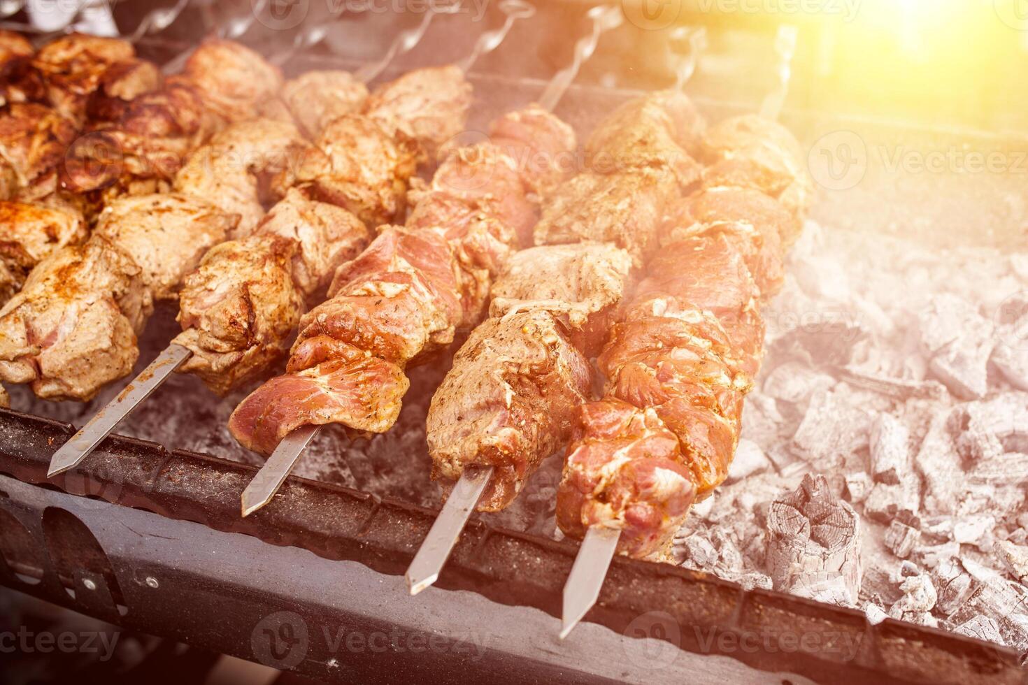 Grilled kebab cooking on metal skewer. Roasted meat cooked at barbecue. BBQ fresh beef meat chop slices. Traditional eastern dish, shish kebab. photo