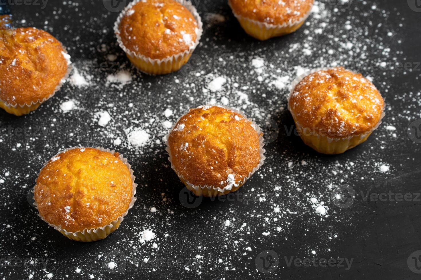 apetitoso magdalenas estar en un mesa parte superior vista. tradicional pasteles en un oscuro antecedentes minimalismo foto