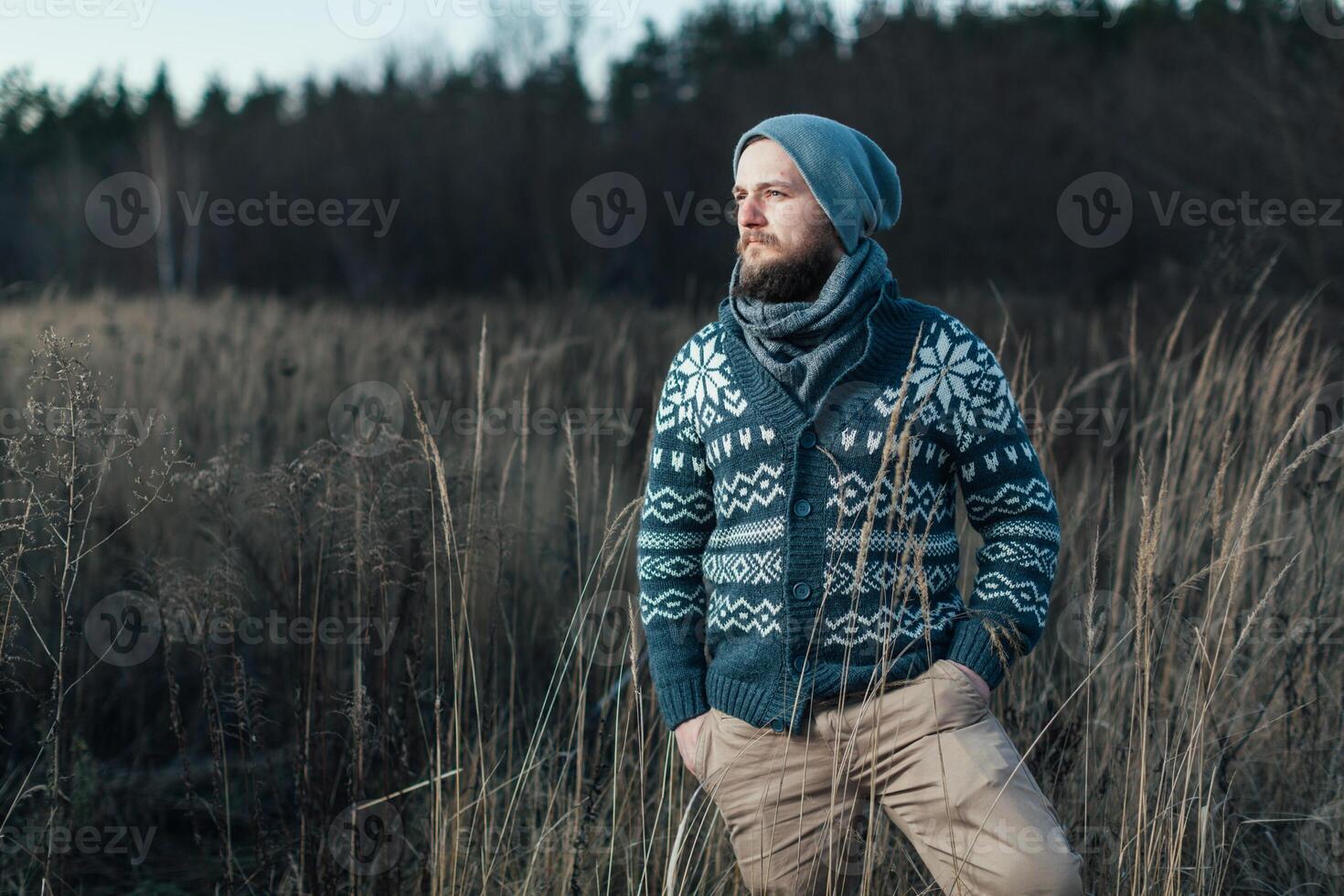 Side view of hipster stylish man. He standing on the autumn field and planing where he go photo