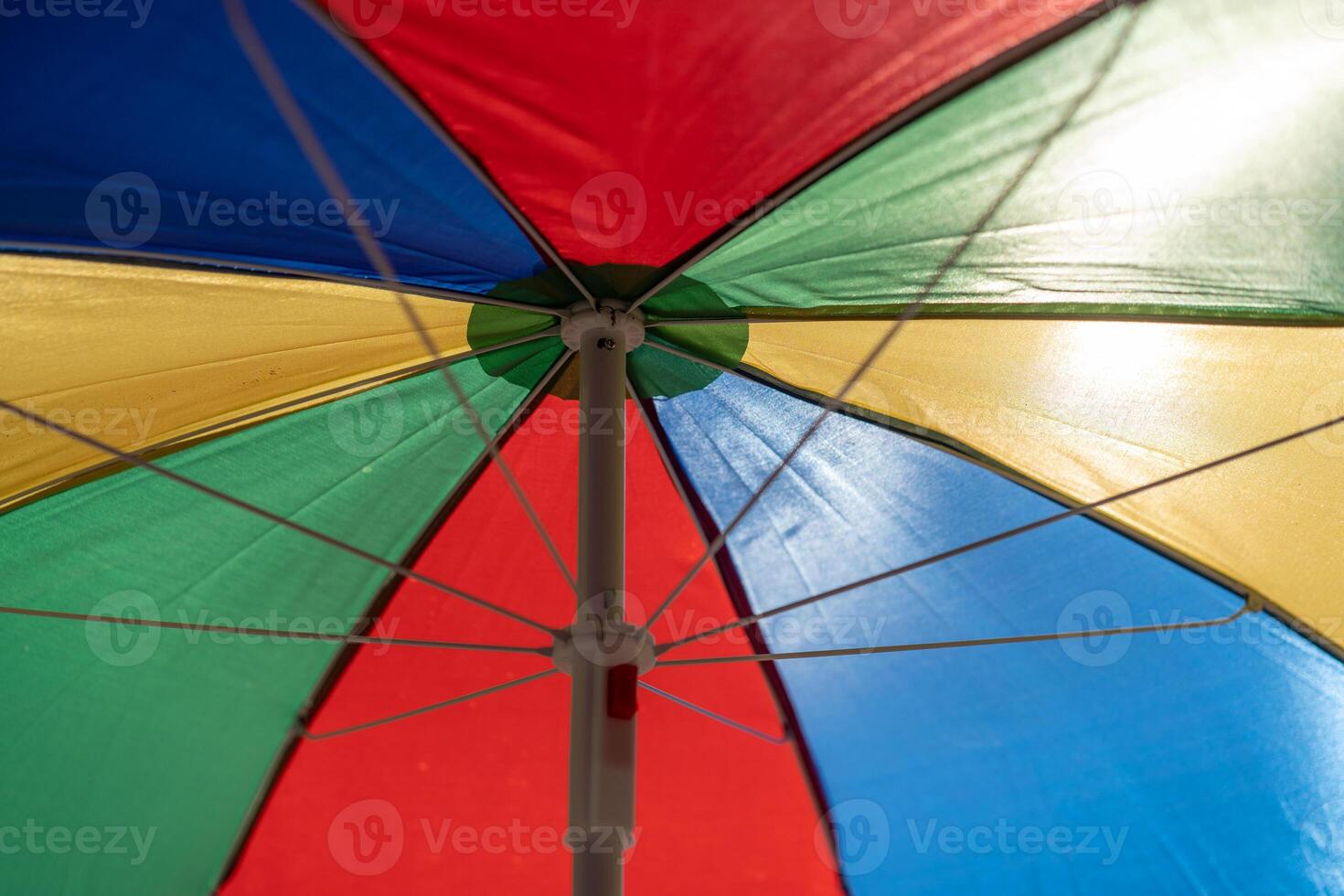 multicolored umbrella open to the sun. Bottom view on the inside photo