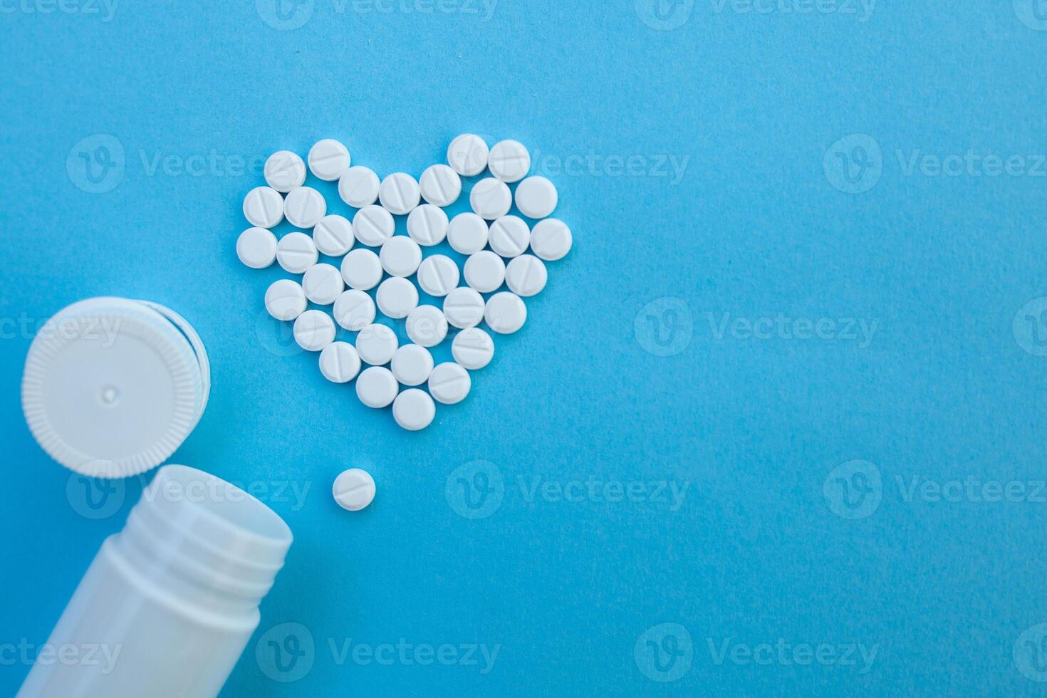 medicine, healthcare and pharmacy concept - pills and of drugs in shape of the heart photo