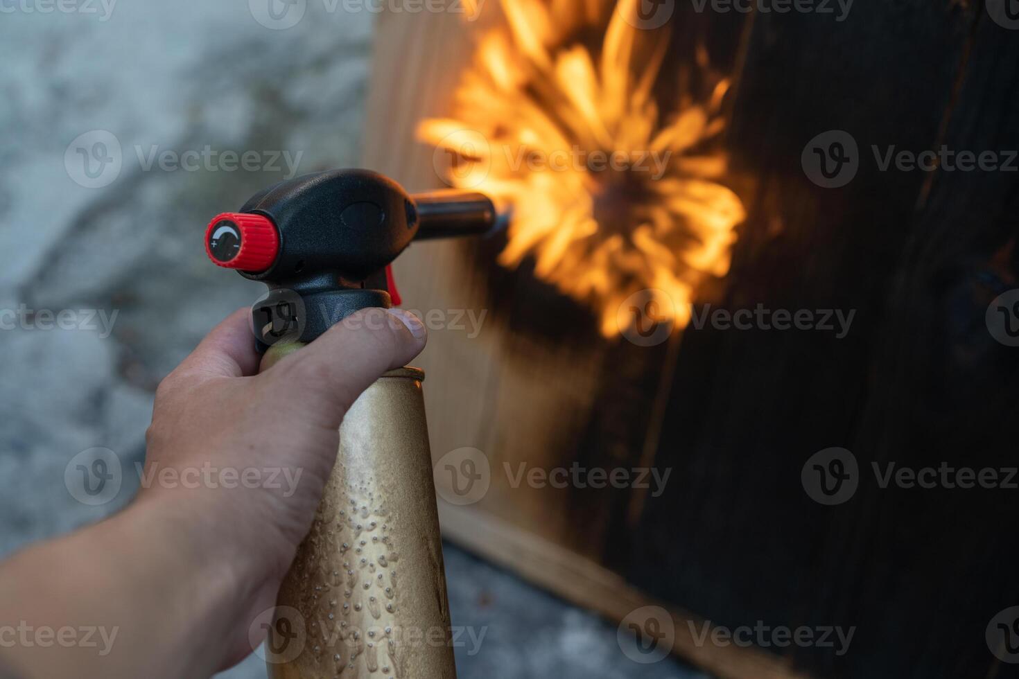 Professional carpenter using old traditional japanese technique. Burning wood planks with gas burner photo