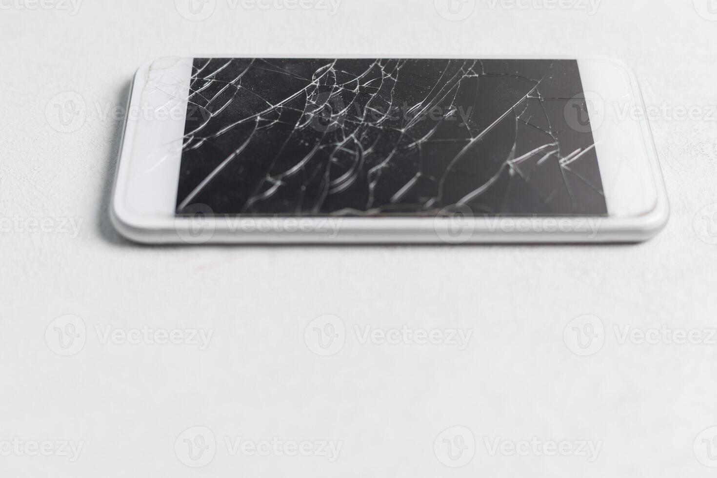 Modern mobile smartphone with broken screen on white background photo