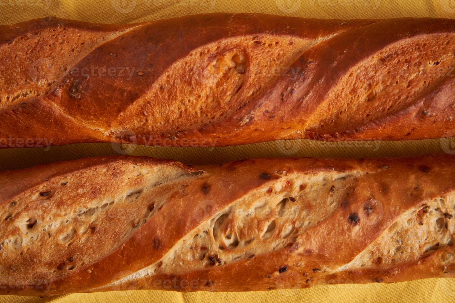 two crispy french baguettes lie on an old wooden table with free space for text photo