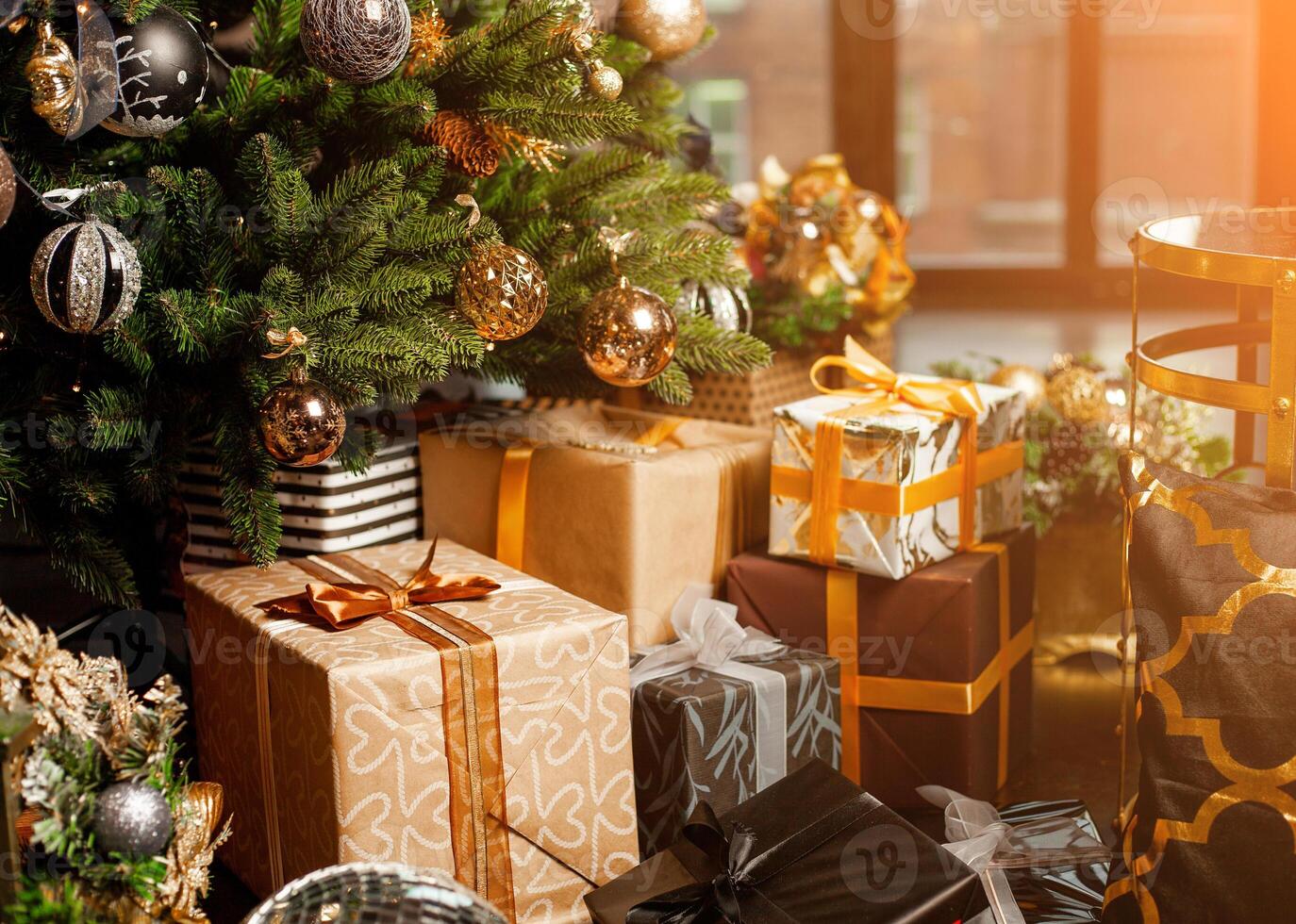 Close-up of a Christmas tree decorated with gold balls. Under the Christmas tree a large number of Christmas gifts. Christmas holiday concept photo