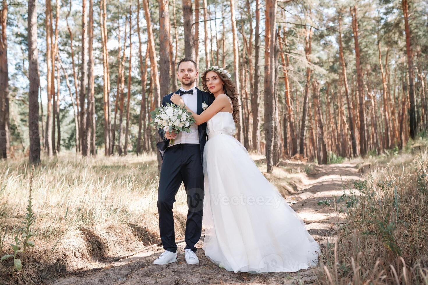 novia y novio a Boda día caminando al aire libre en verano naturaleza. nupcial pareja, contento recién casado mujer y hombre abrazando en verde parque. amoroso Boda Pareja exterior. novia y novio foto