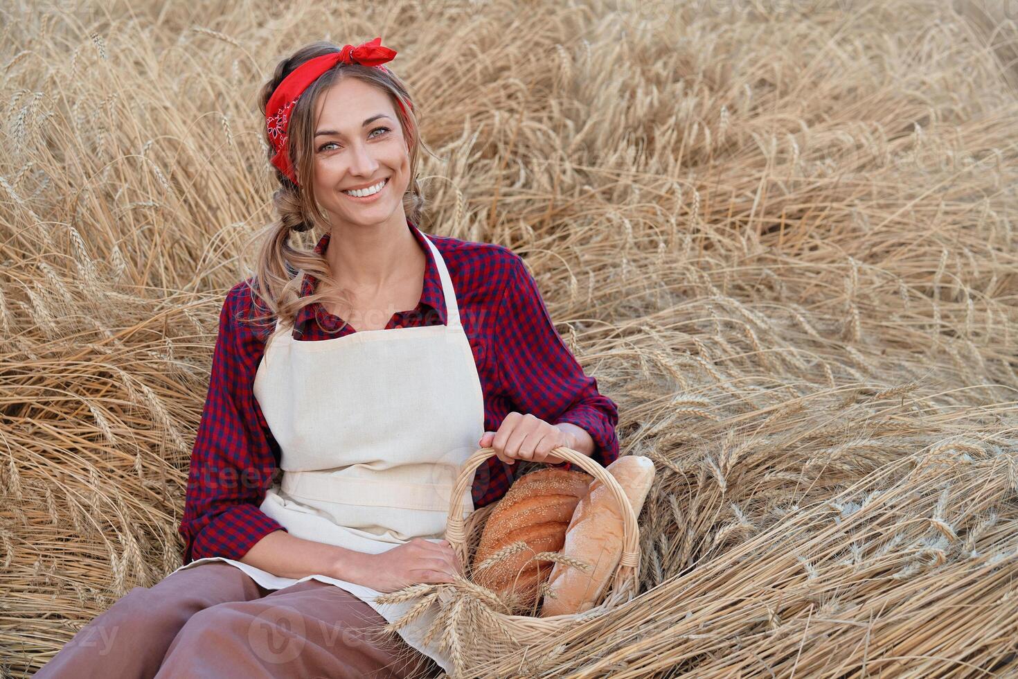 Female farmer sitting wheat agricultural field Woman baker holding wicker basket bread product photo