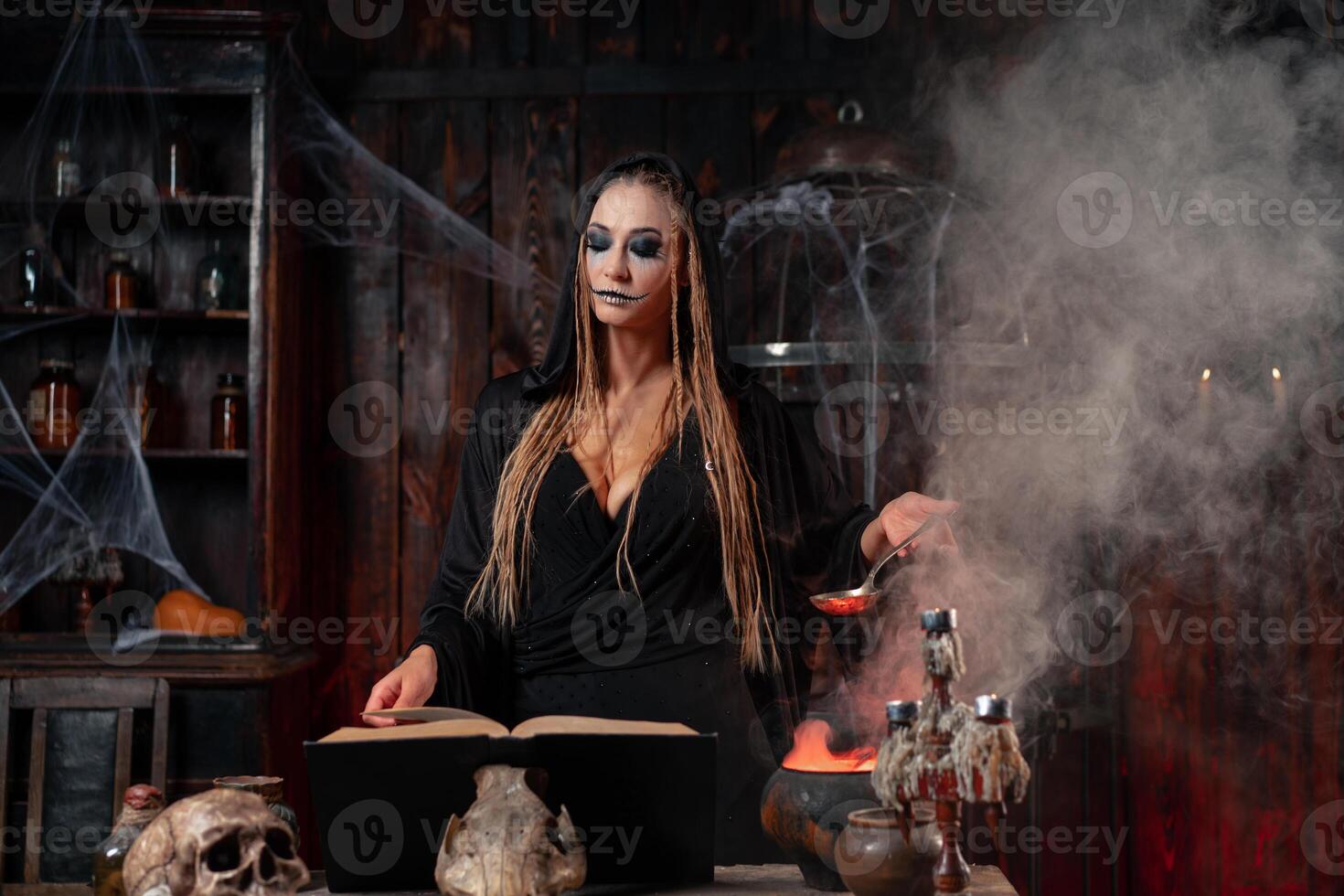 Halloween, witch use magic book and cauldron prepare poison or love potion photo