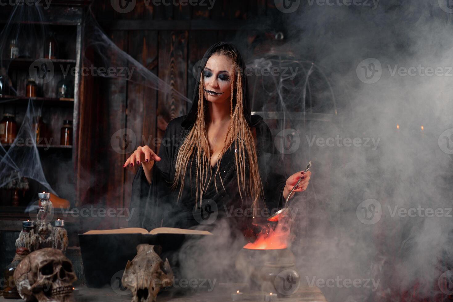 Víspera de Todos los Santos, bruja utilizar magia libro y caldera preparar veneno o amor poción foto