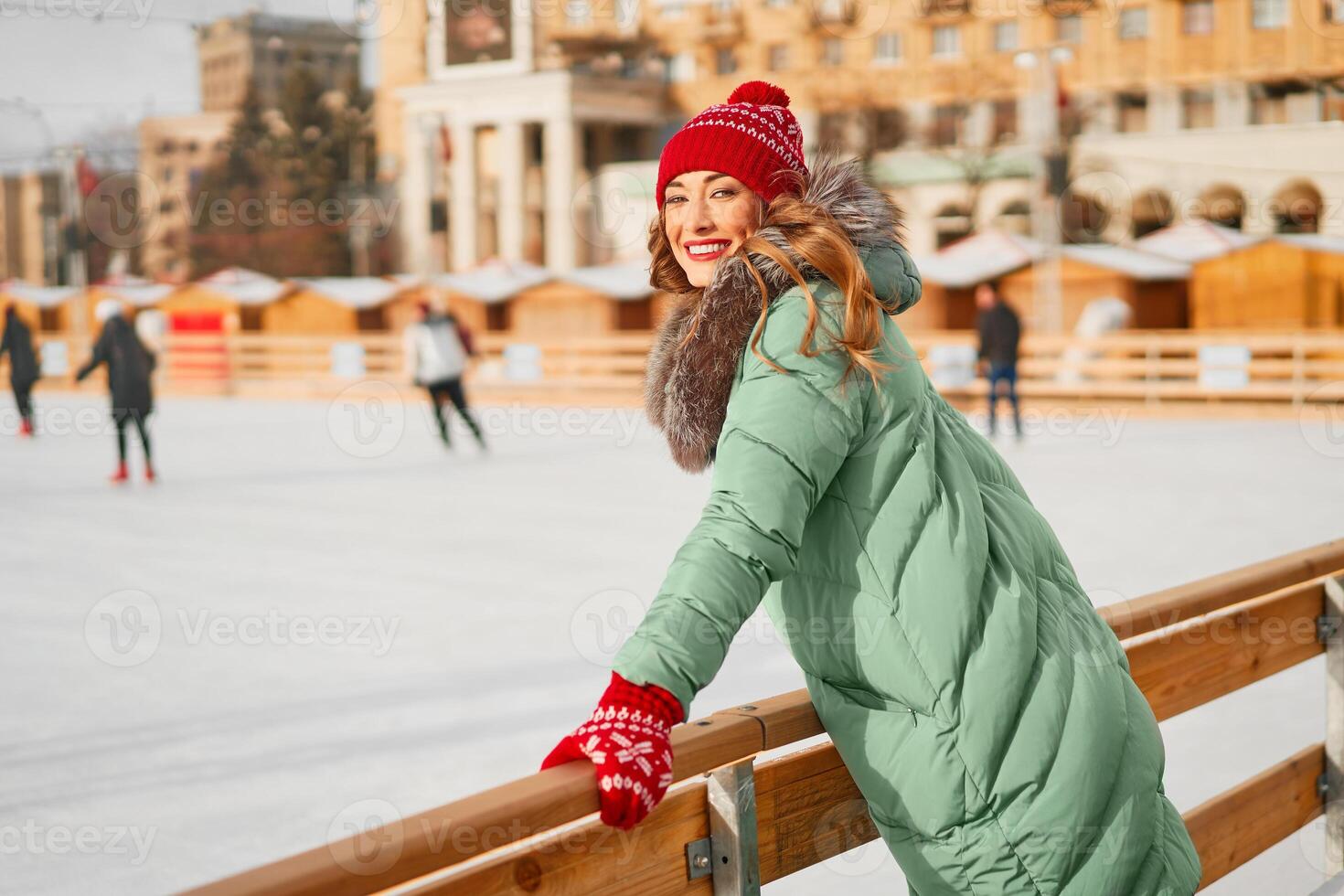 Beautiful lovely middle-aged girl with curly hair warm winter jackets stands ice rink background Town Square. photo