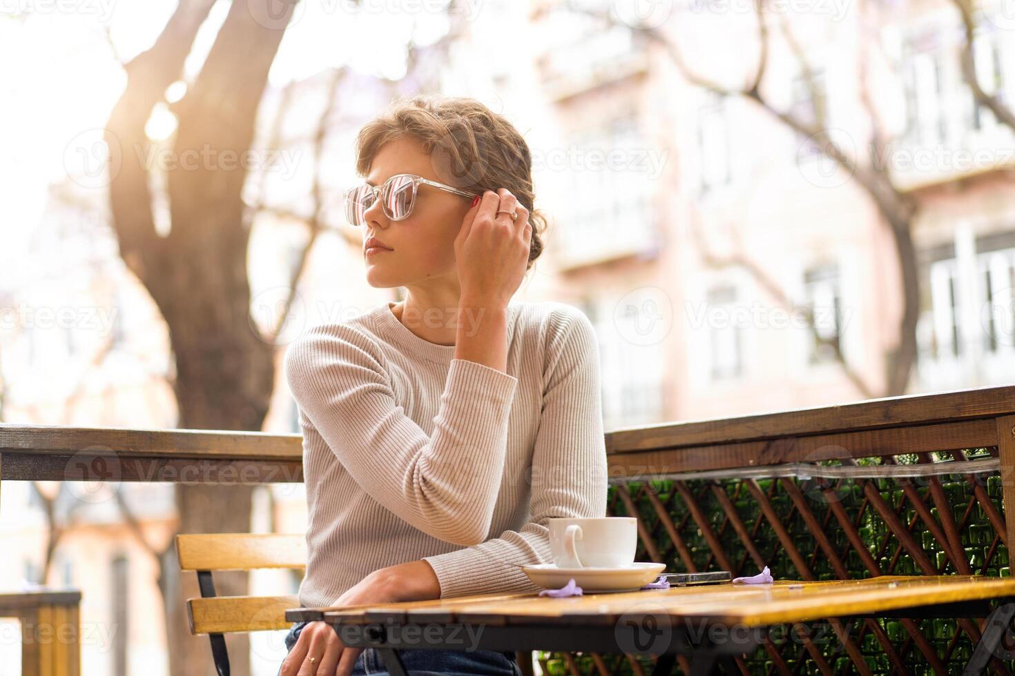 Portrait of thoughtful young woman sitting outdoor cafeteria photo