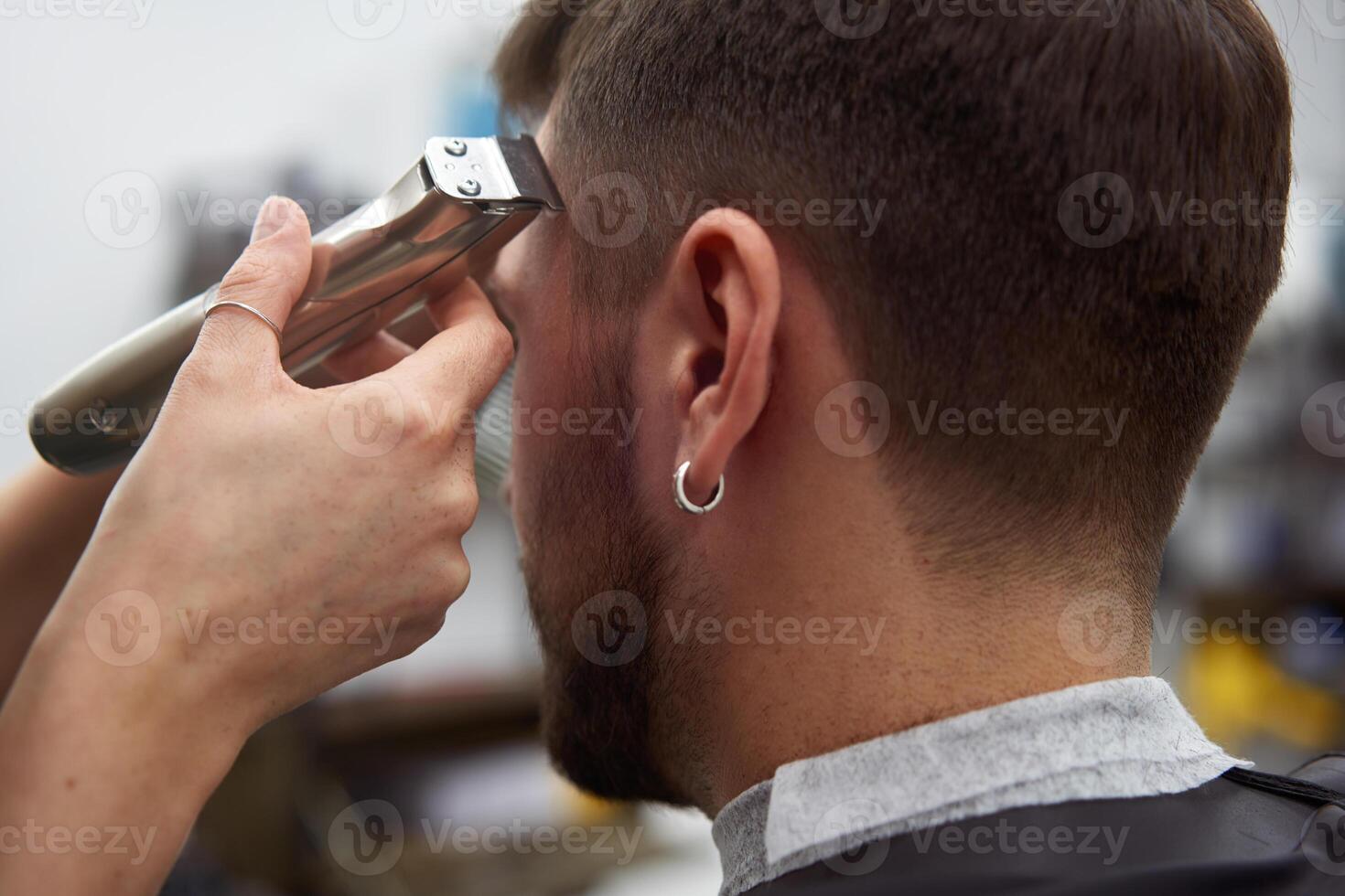 Beautiful caucasian woman hairdresser doing hairstyle to client. photo