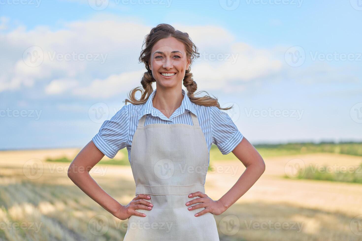 Woman farmer apron standing farmland smiling Female agronomist specialist farming agribusiness Happy positive caucasian worker agricultural field photo