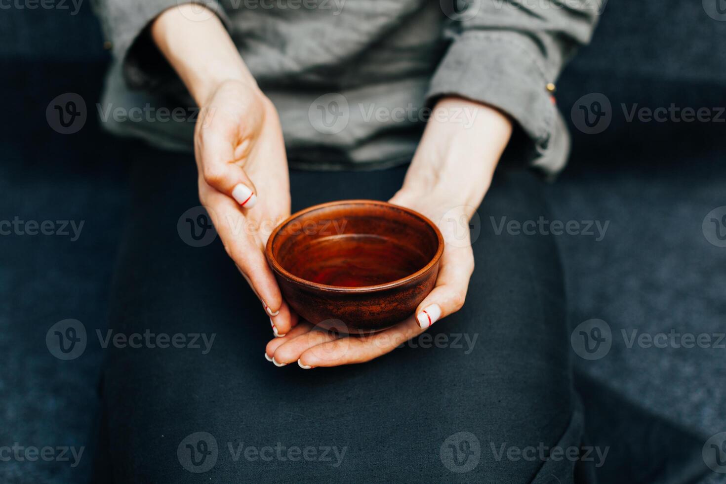 Woman offers hot tea in a vintage ceramic cup. photo