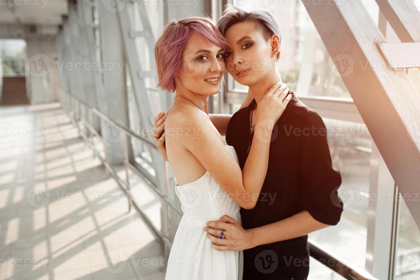 people, homosexuality, same-sex marriage, travel and gay love concept - close up of happy women couple hugging over metall bridge. Two girlfriend walking. photo
