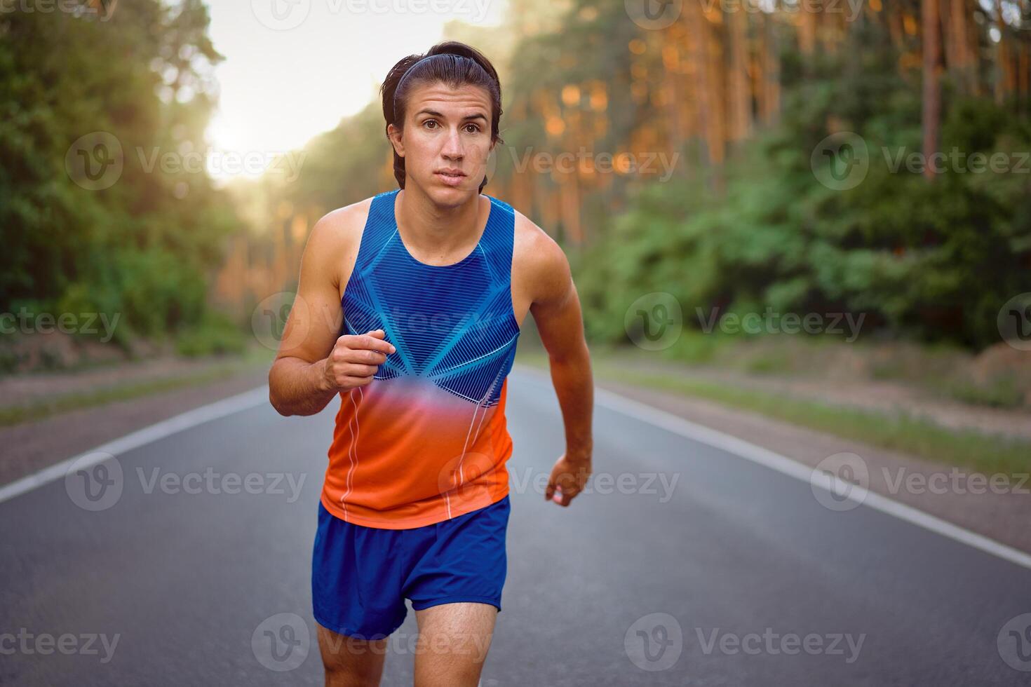 Caucasian middle age man athlete runs sunny summer day on asphalt road in the forest. photo