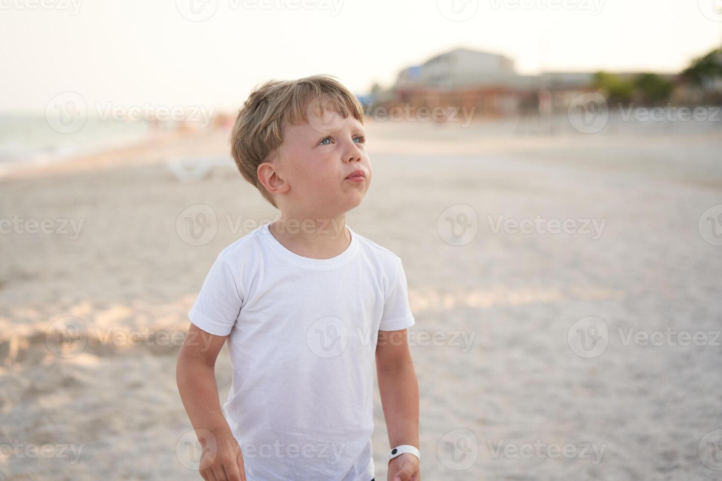 Caucasian boy standing beach. Childhood summertime. Family vacation photo