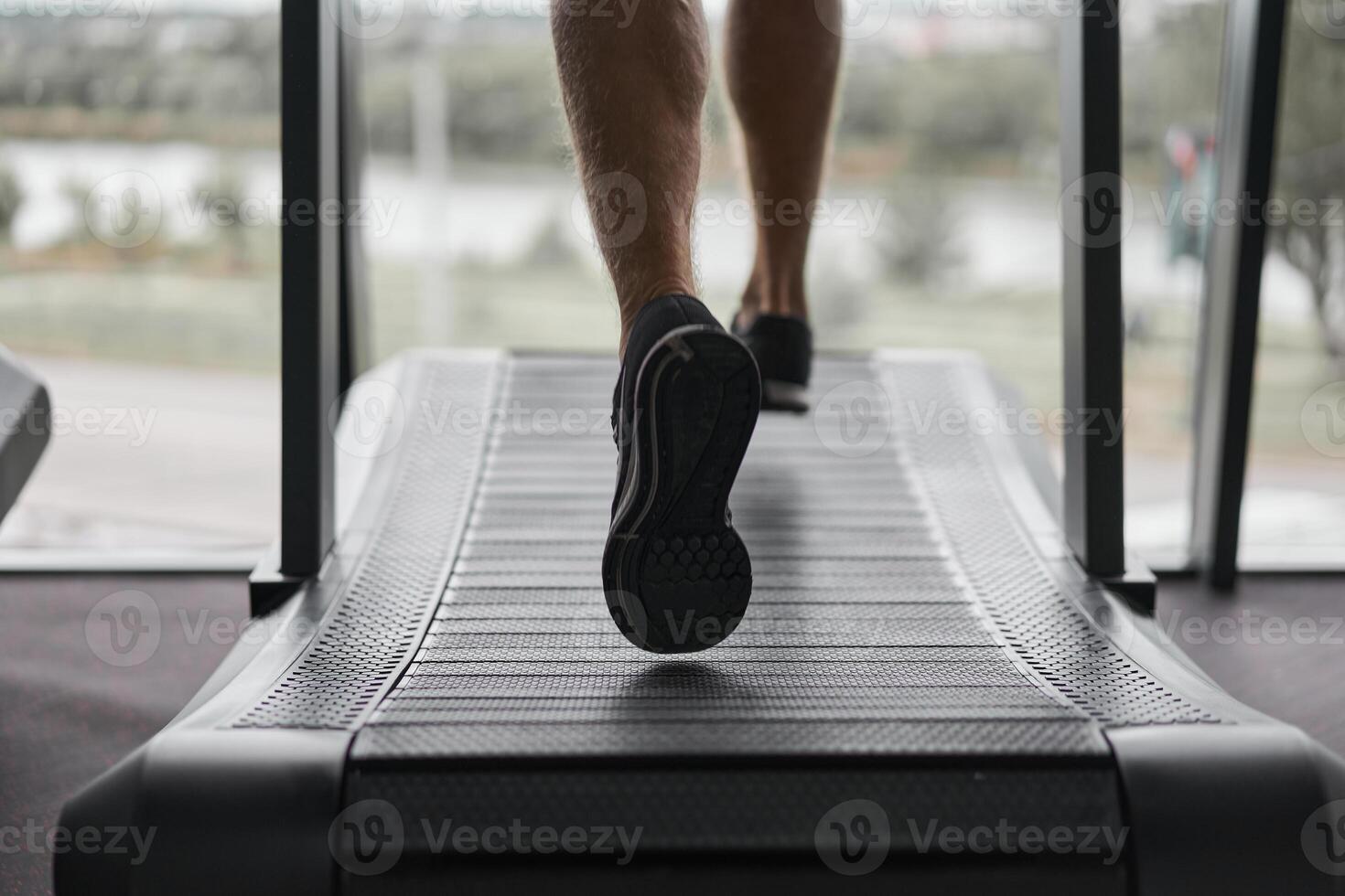 Unrecognizable Man running treadmill gym Athlete jogging indoor Weight loss workout jogger run gray wall background Cardio training photo