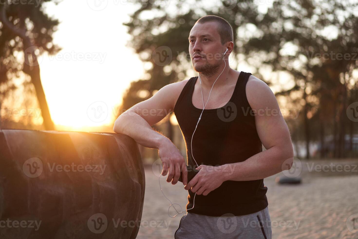 Young adult caucasian athlete listening phone music white headphones after workout. photo