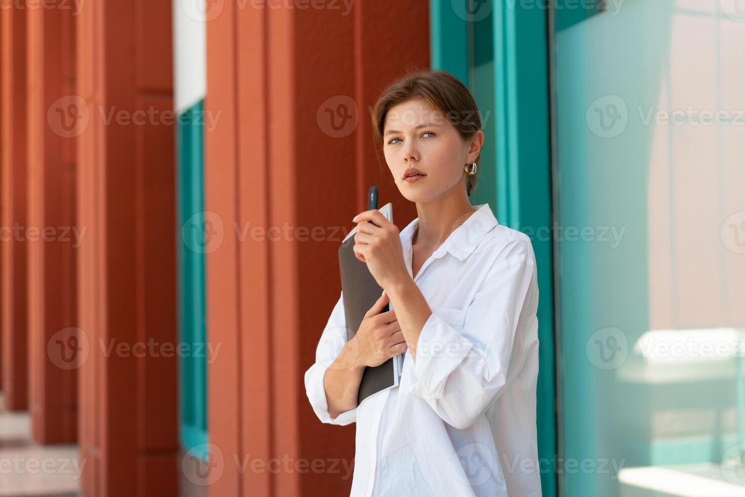 Businesswoman smoking e-cigarette. Caucasian frustrated female business person pensive standing street lost her job has financial problems smoking electronic cigarette. photo