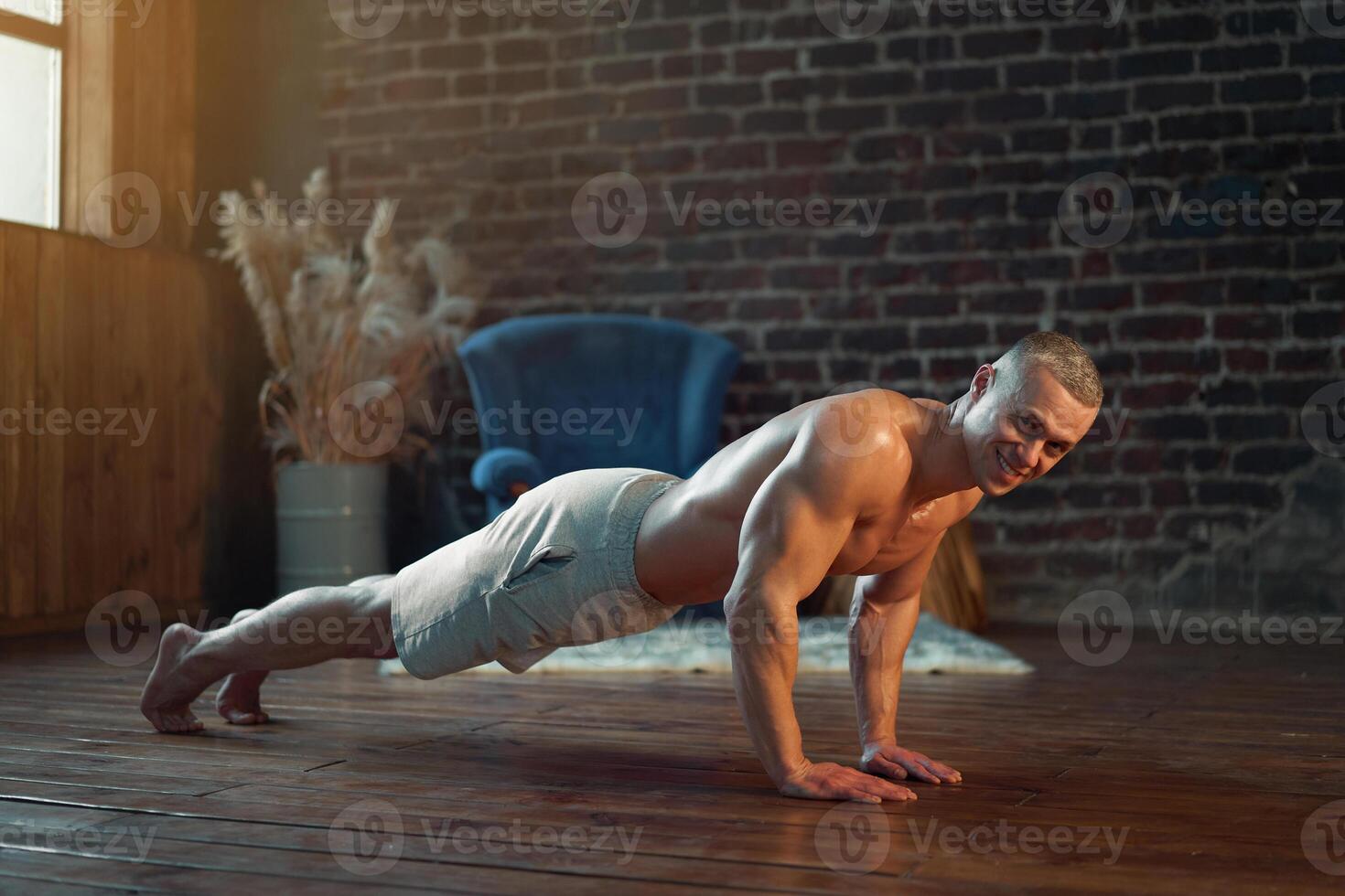 Endurance workout. Muscular man practicing push ups exercise at home interior photo
