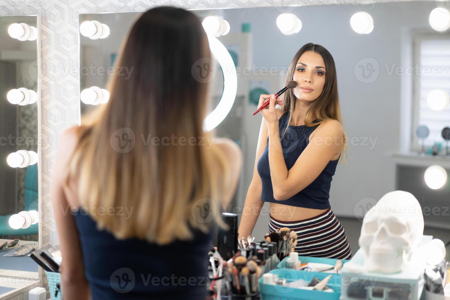 retrato de bonito hembra cosmetólogo en pie posando a lugar de trabajo en pelo y belleza salón foto