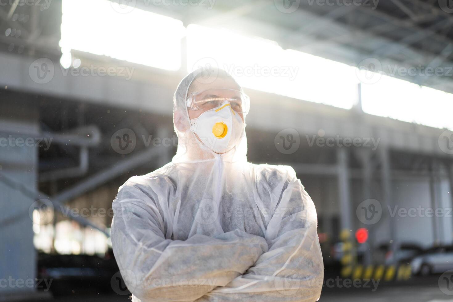 COVID-19 coronavirus doctor standing hospital parking dressed white protective overalls hazmat suit. photo