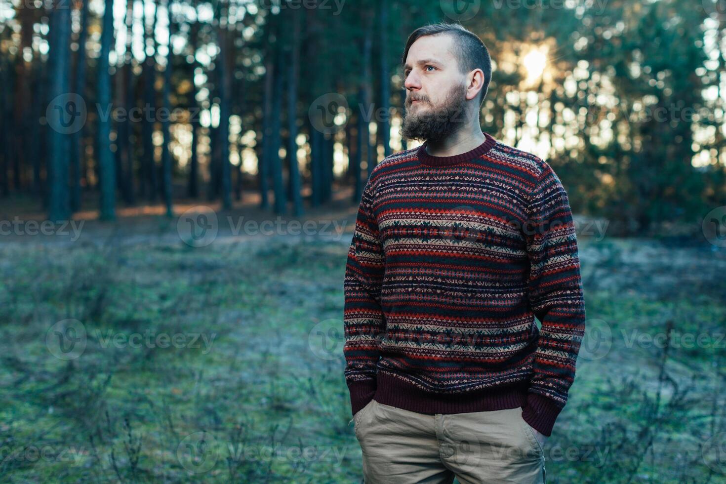 Portrait brutal bearded hipster man in the forest photo