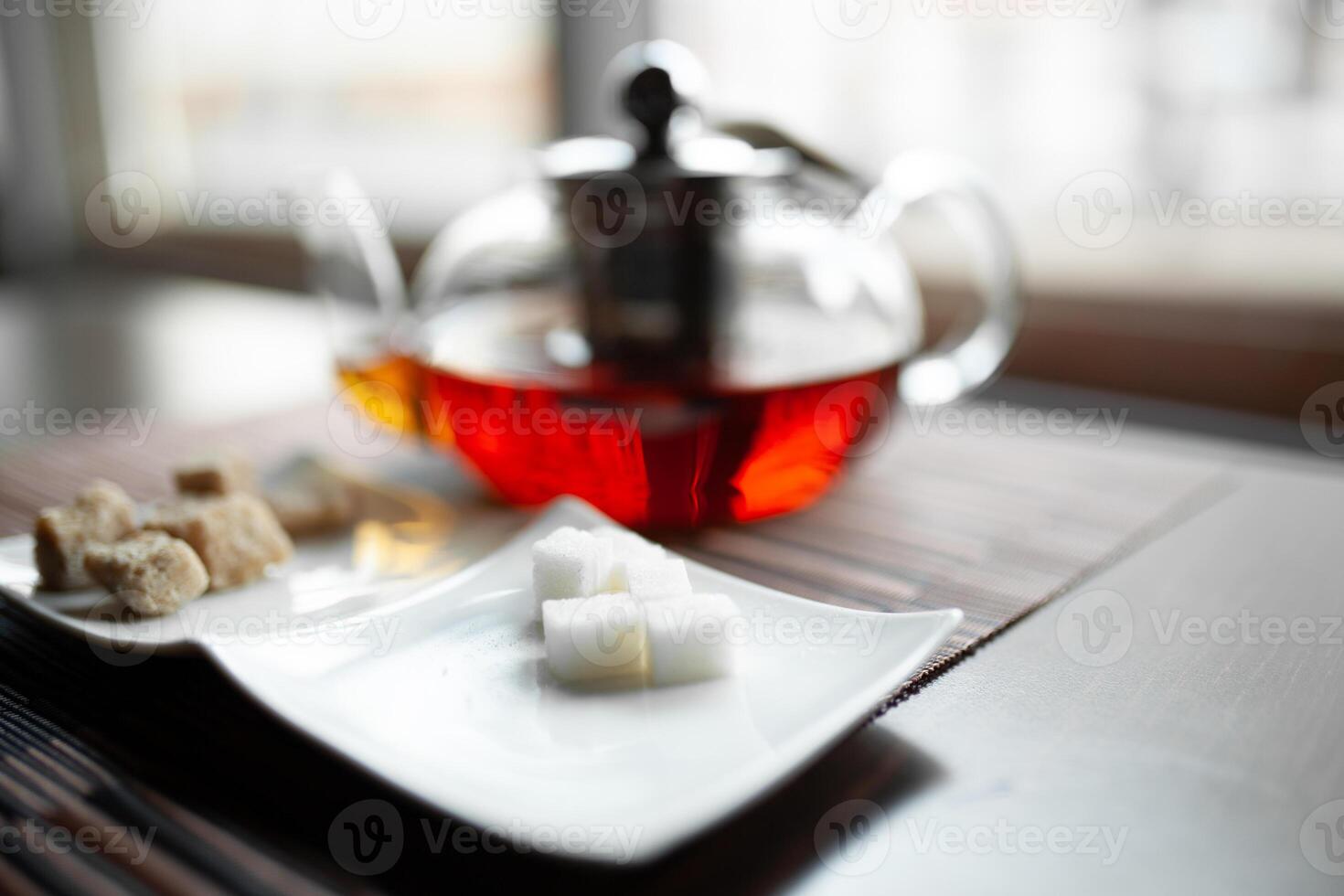 Glass teapot of invigorating fresh aromatic tea on a wooden photo