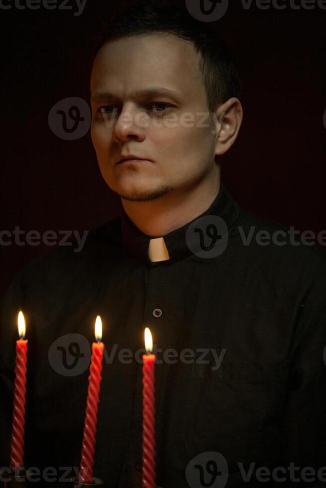 retrato de hermoso católico sacerdote o pastor con perro cuello, oscuro rojo antecedentes. foto