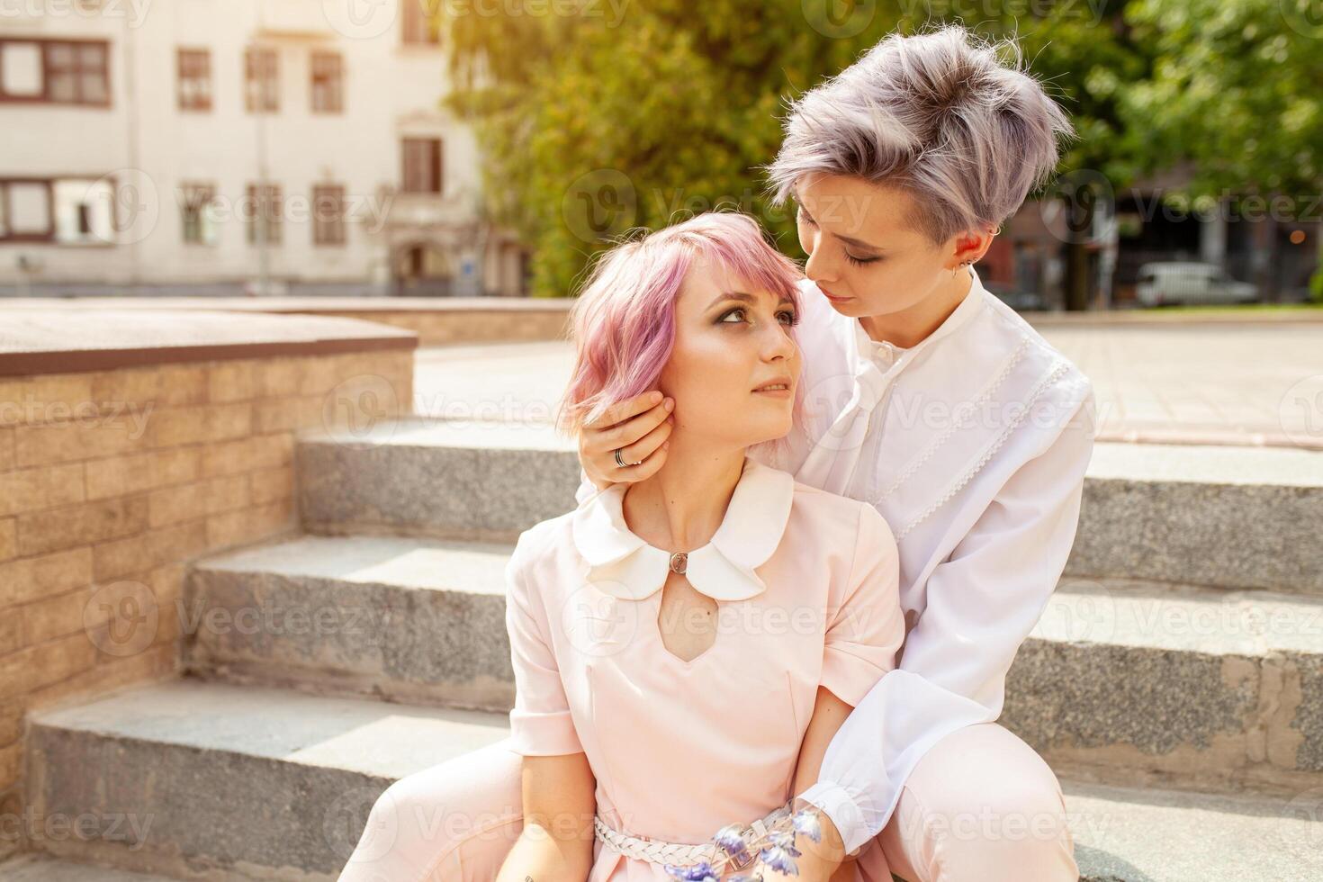 dos lesbiana muchachas sentado en el escalera en el ciudad foto