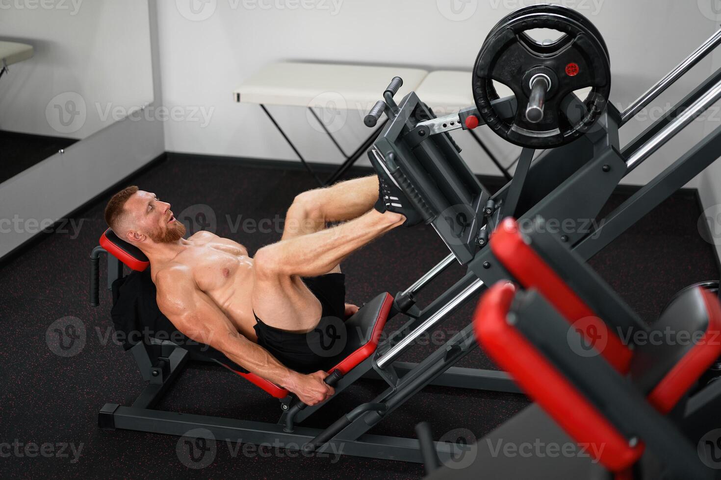 Gym man leg press machine training pushing weight training legs muscule photo