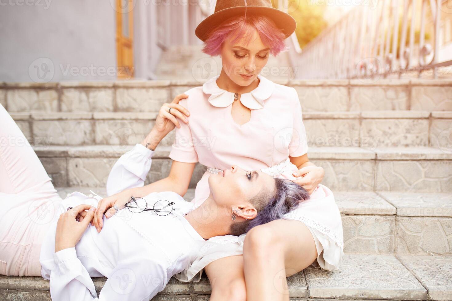 Two lesbian girls sitting on the stairs in the city photo