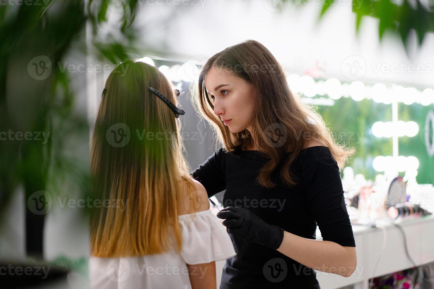 joven cosmetólogo caucásico niña sostiene modelo ceja corrección foto