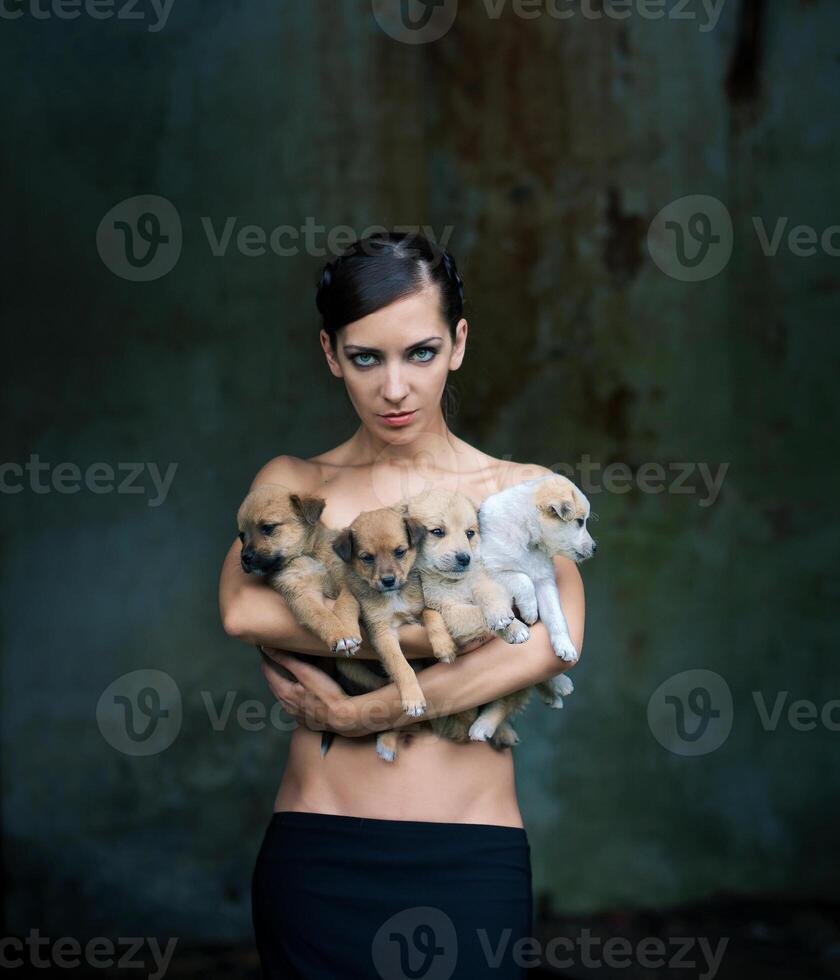 Beautiful woman holding four puppies. photo