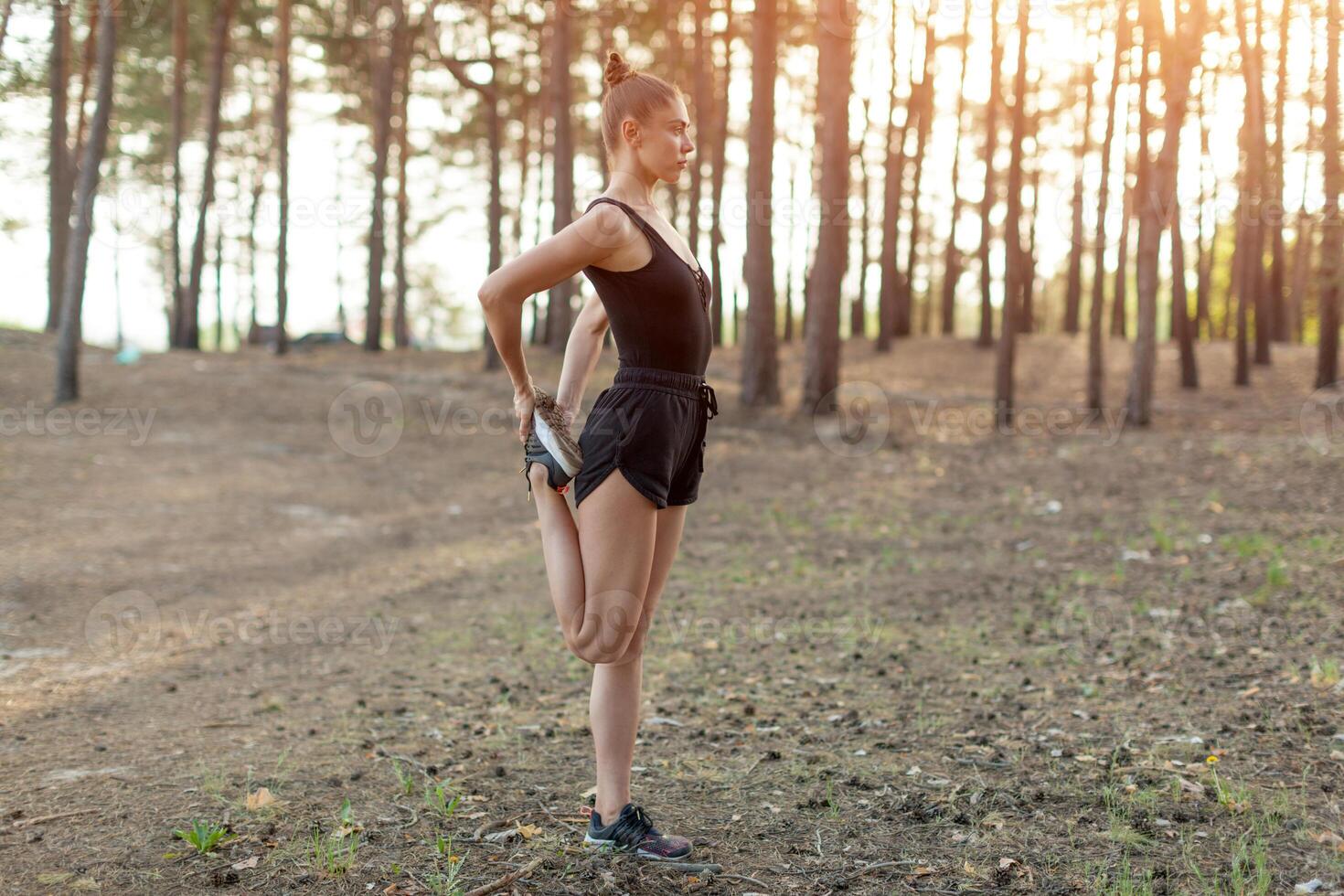 Young caucasian girl on a morning run in a pine forest. Exercises in nature and a healthy lifestyle photo