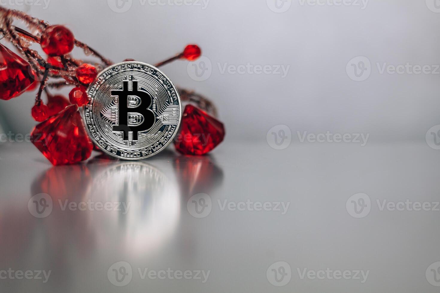 silver bitcoin stands on the table leaning on the giver with precious stones photo