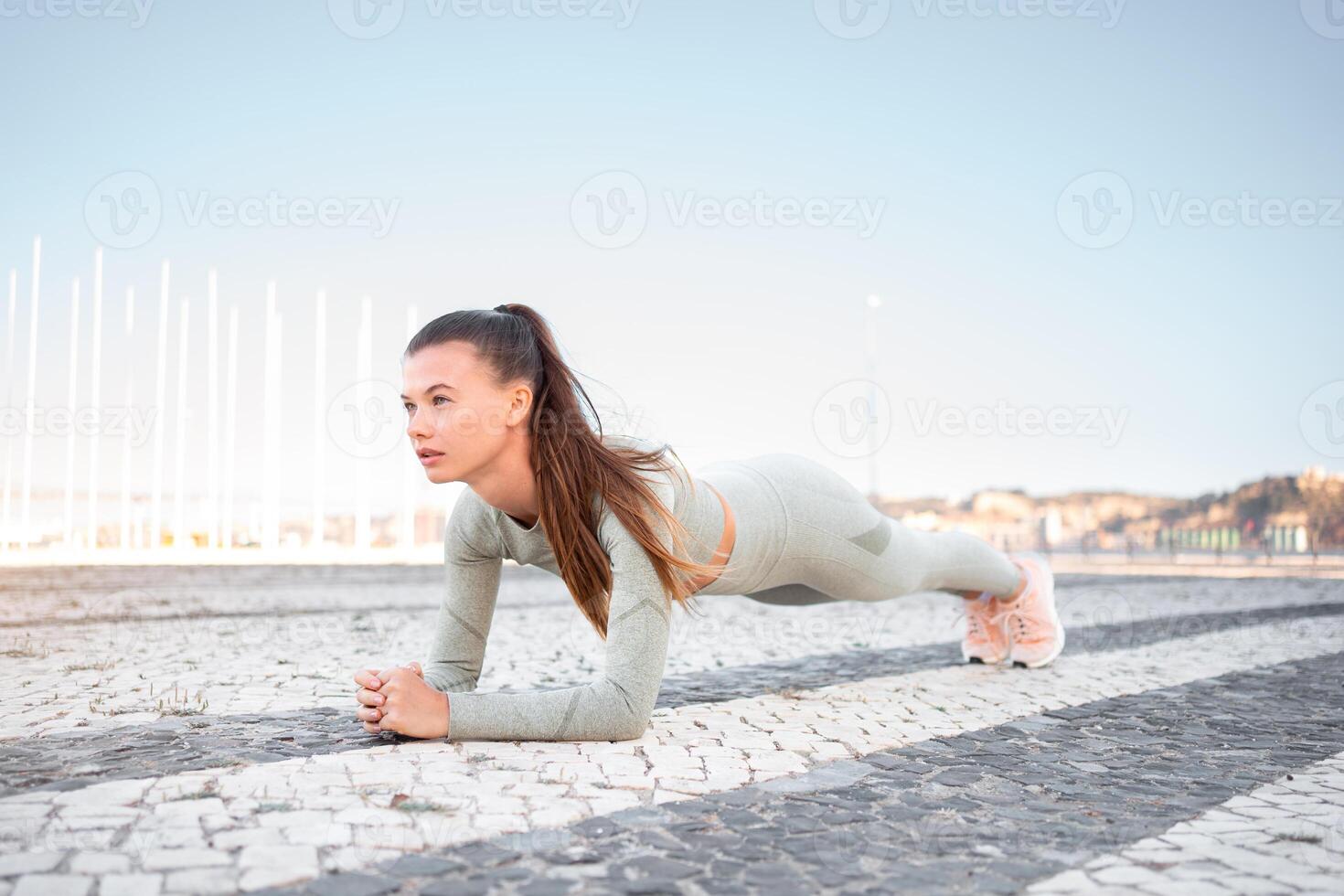 Full length, strong fit girl sportswear training plank outdoor photo