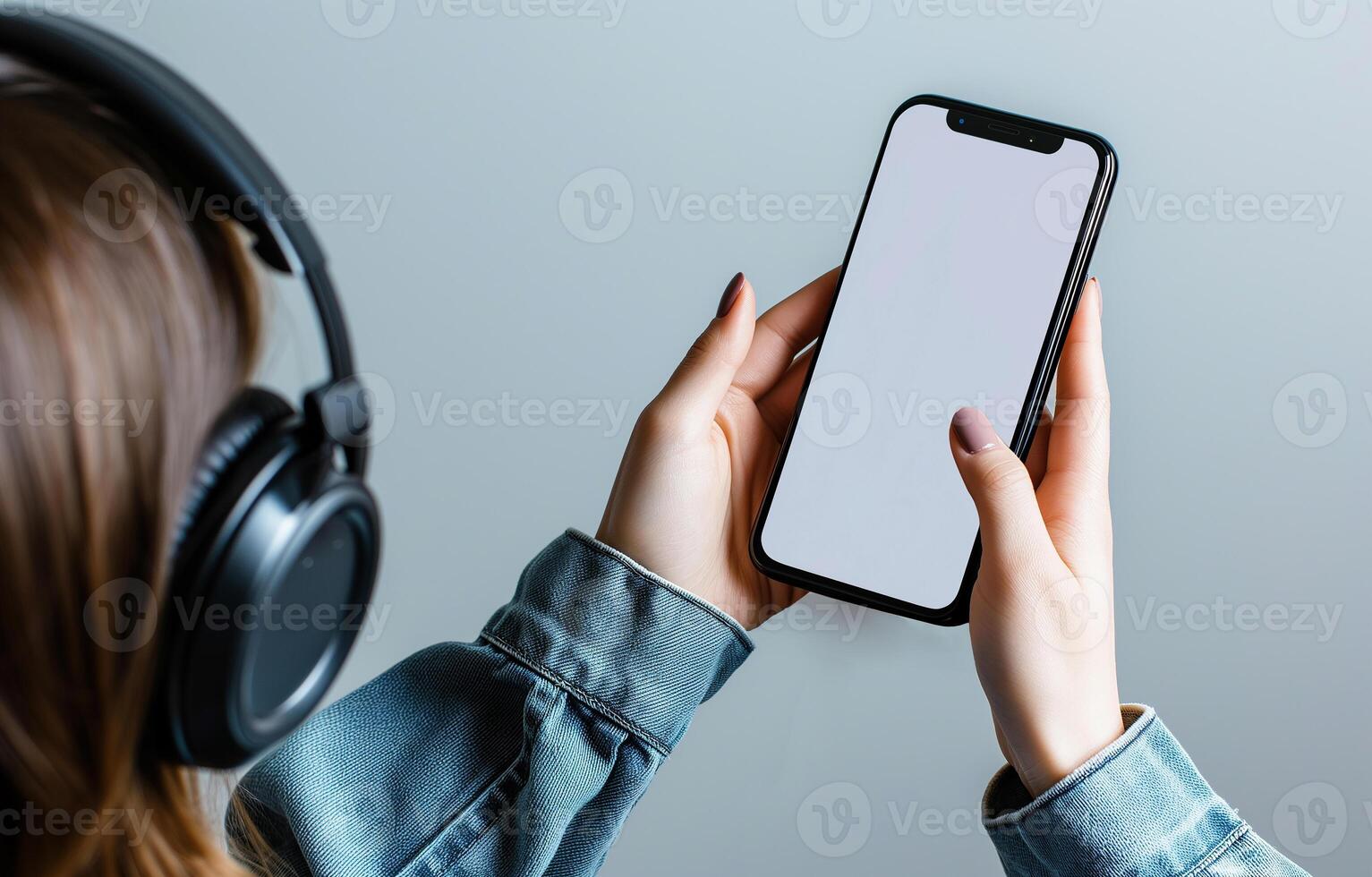 AI generated A young dark-haired woman listening to music with headphones is holding a smartphone with an empty screen. A mockup, a phone, a smartphone. Close-up portrait, bokeh effect photo