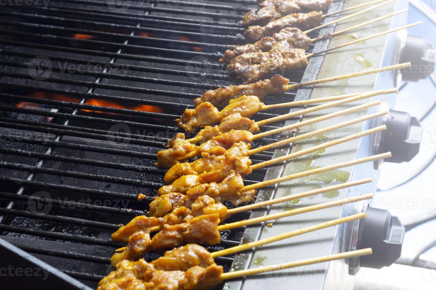 asiático cocina, Malasia pollo satay Cocinando en un caliente carbón parrilla. foto