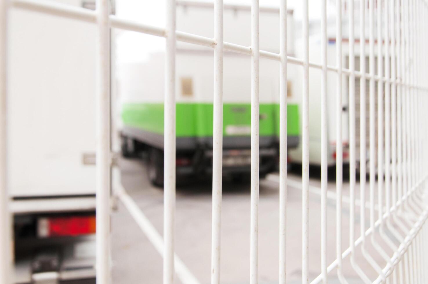 Blurred background, trucks for rent behind a fence photo