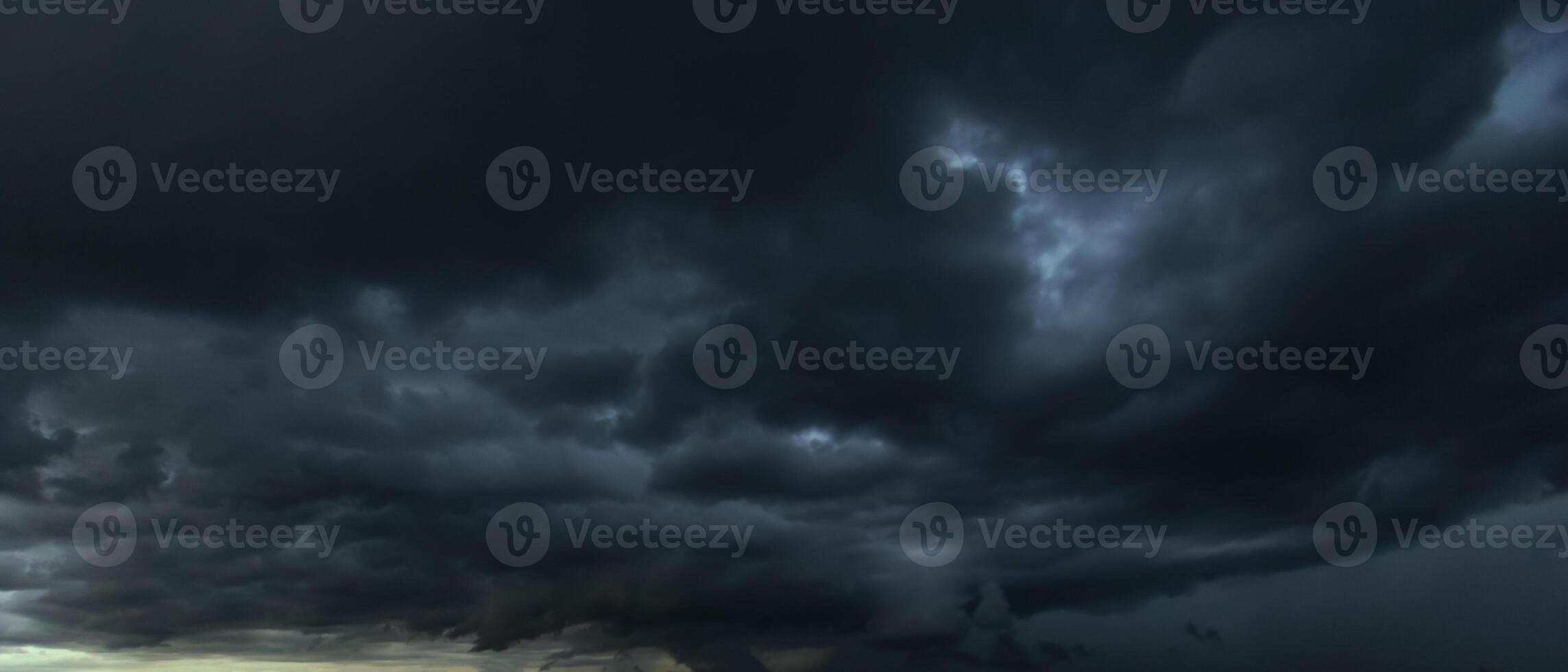 The dark sky with heavy clouds converging and a violent storm before the rain.Bad or moody weather sky and environment. carbon dioxide emissions, greenhouse effect, global warming, climate change photo