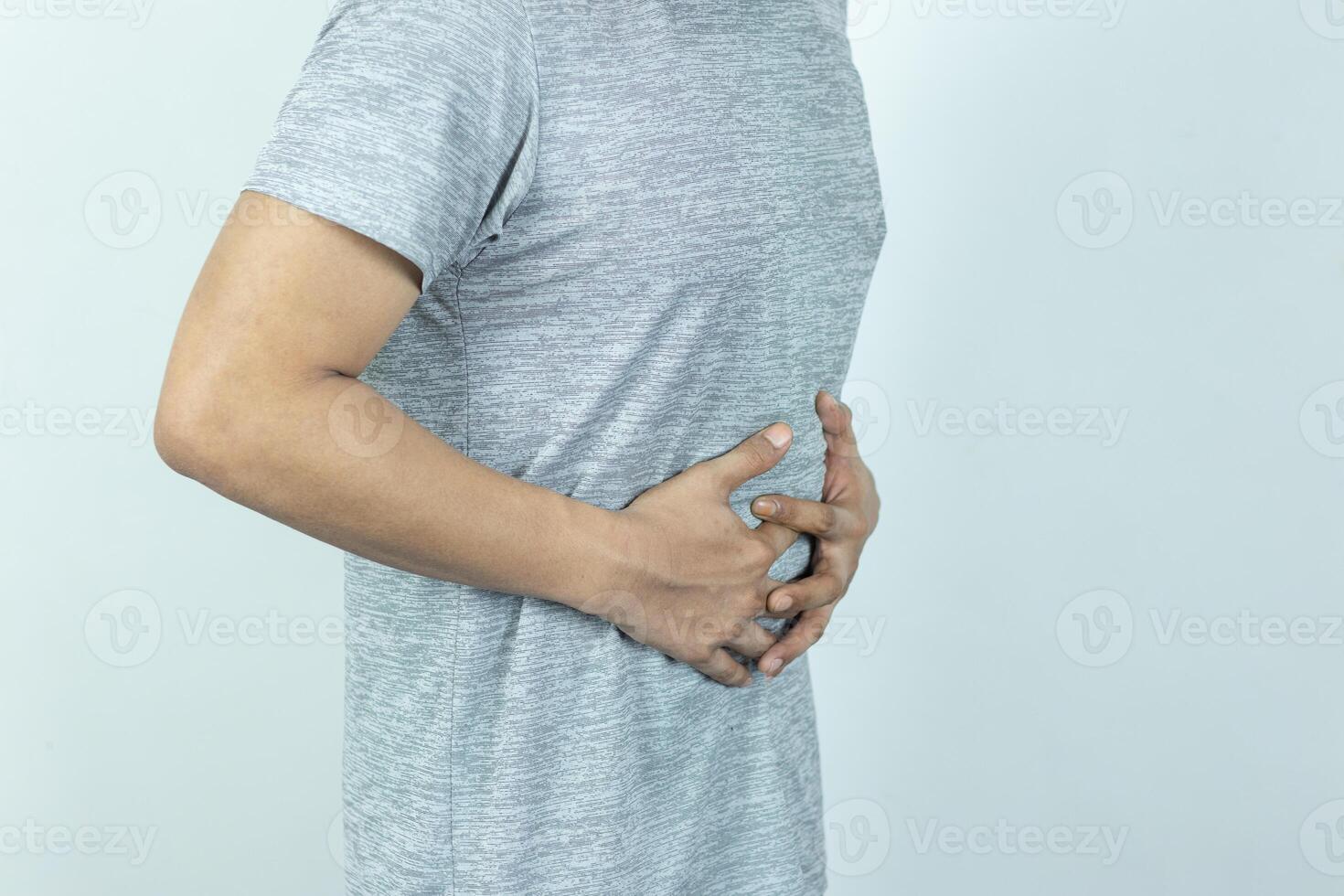 Man suffering with severe stomach pain. Hand of mature guy holding abdomen suffering from ache, diarrhea or indigestion problem. photo