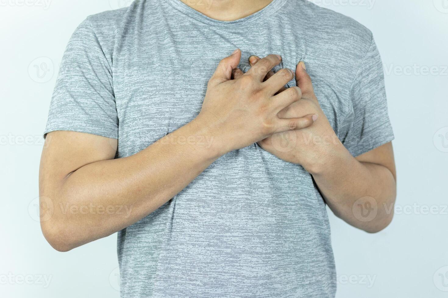 asian man pressing chest with painful expression. Severe heartache, having a heart attack or painful cramps, heart disease. photo