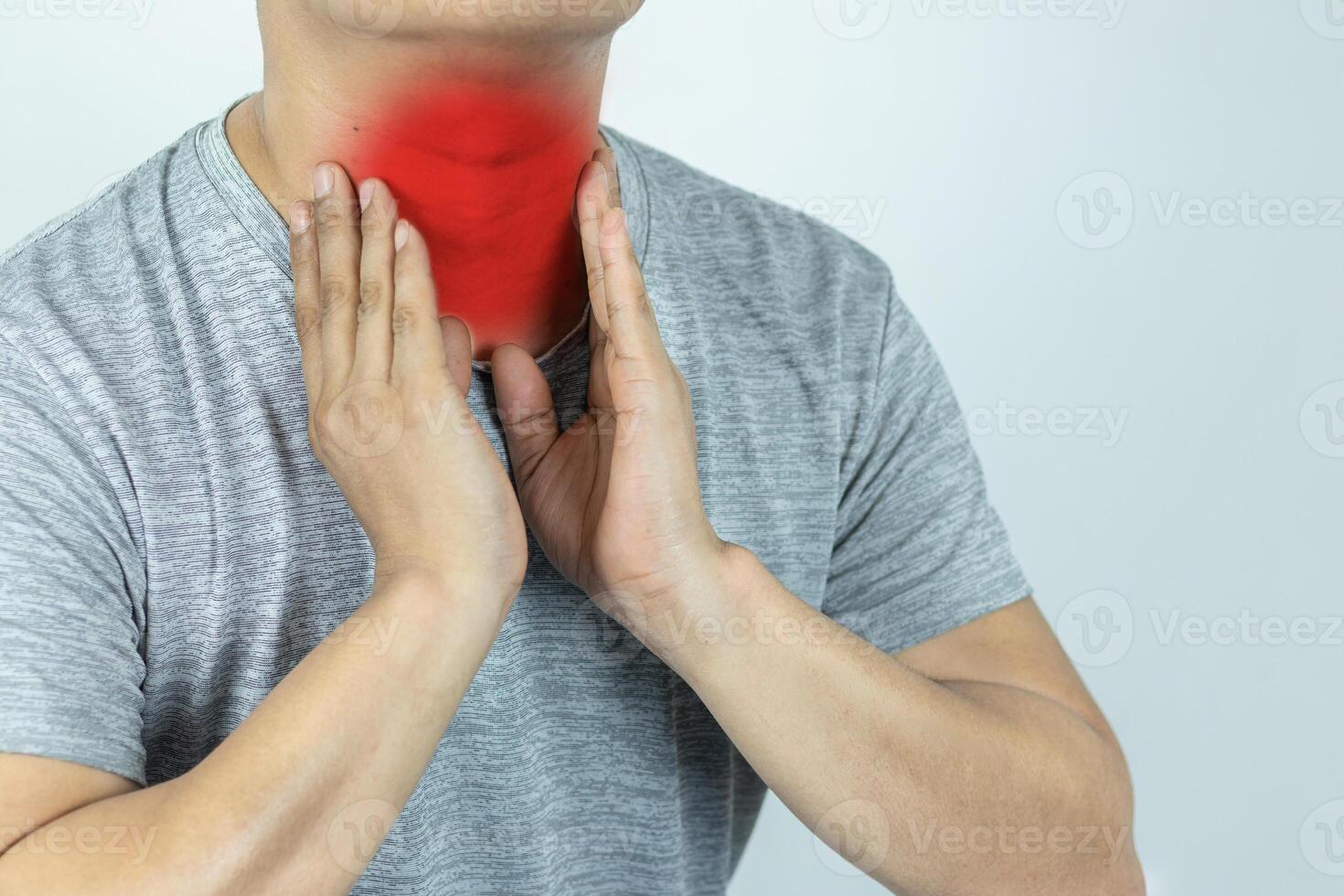 Asian man touching neck with hand because suffering from sore throat photo
