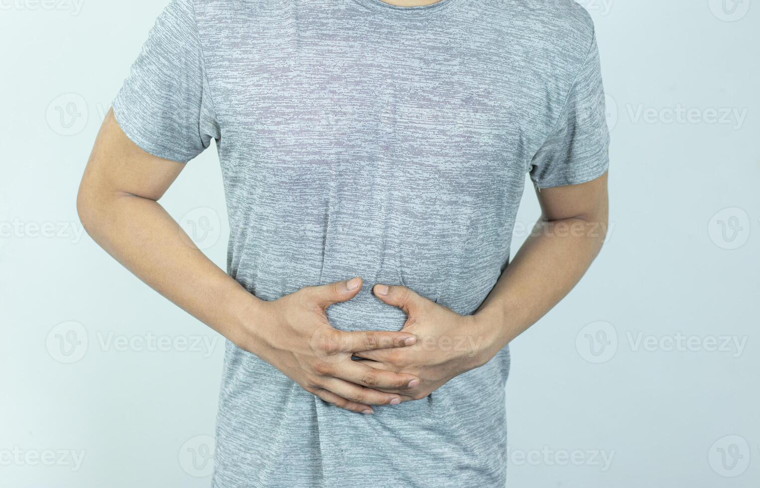 Man suffering with severe stomach pain. Hand of mature guy holding abdomen suffering from ache, diarrhea or indigestion problem. photo