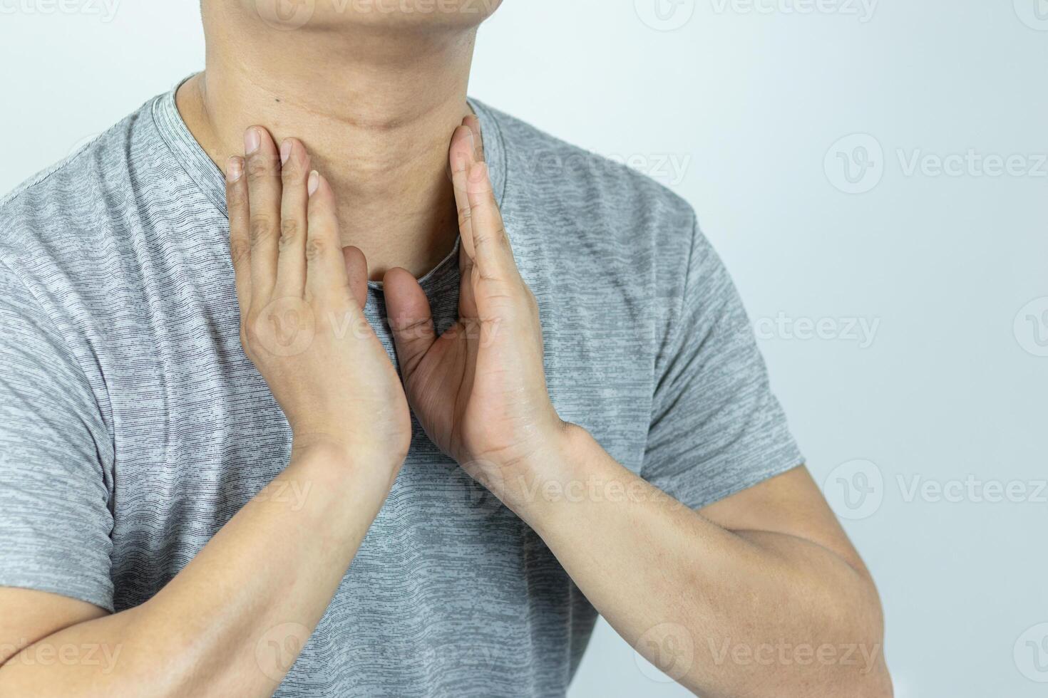 asiático hombre conmovedor cuello con mano porque sufrimiento desde dolorido garganta foto