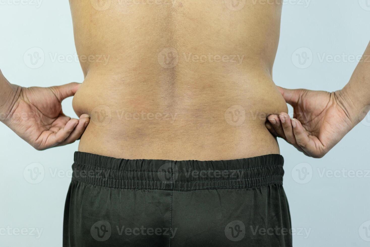 Man touching pot belly or belly fat. Close-up of body parts photo