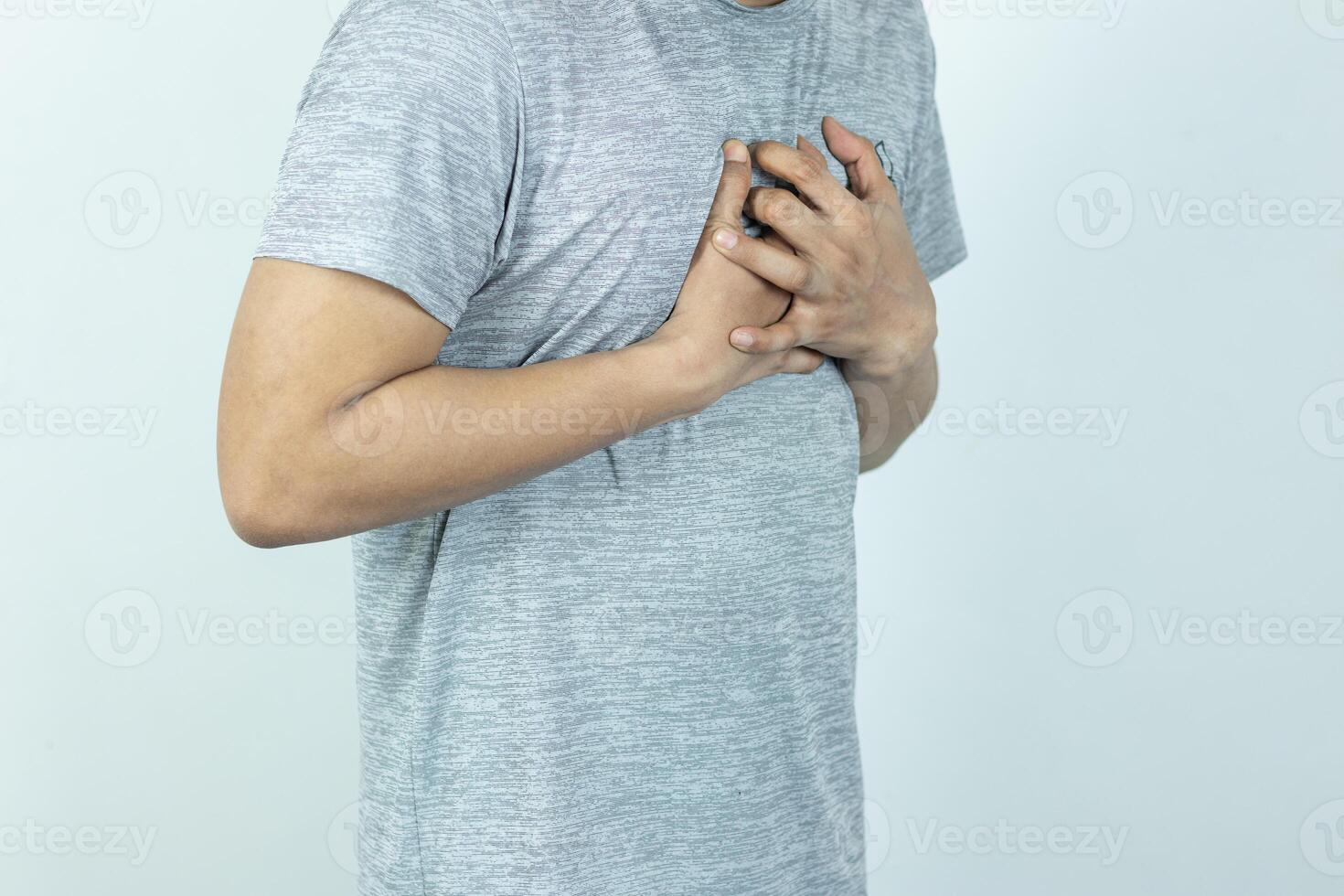 asian man pressing chest with painful expression. Severe heartache, having a heart attack or painful cramps, heart disease. photo