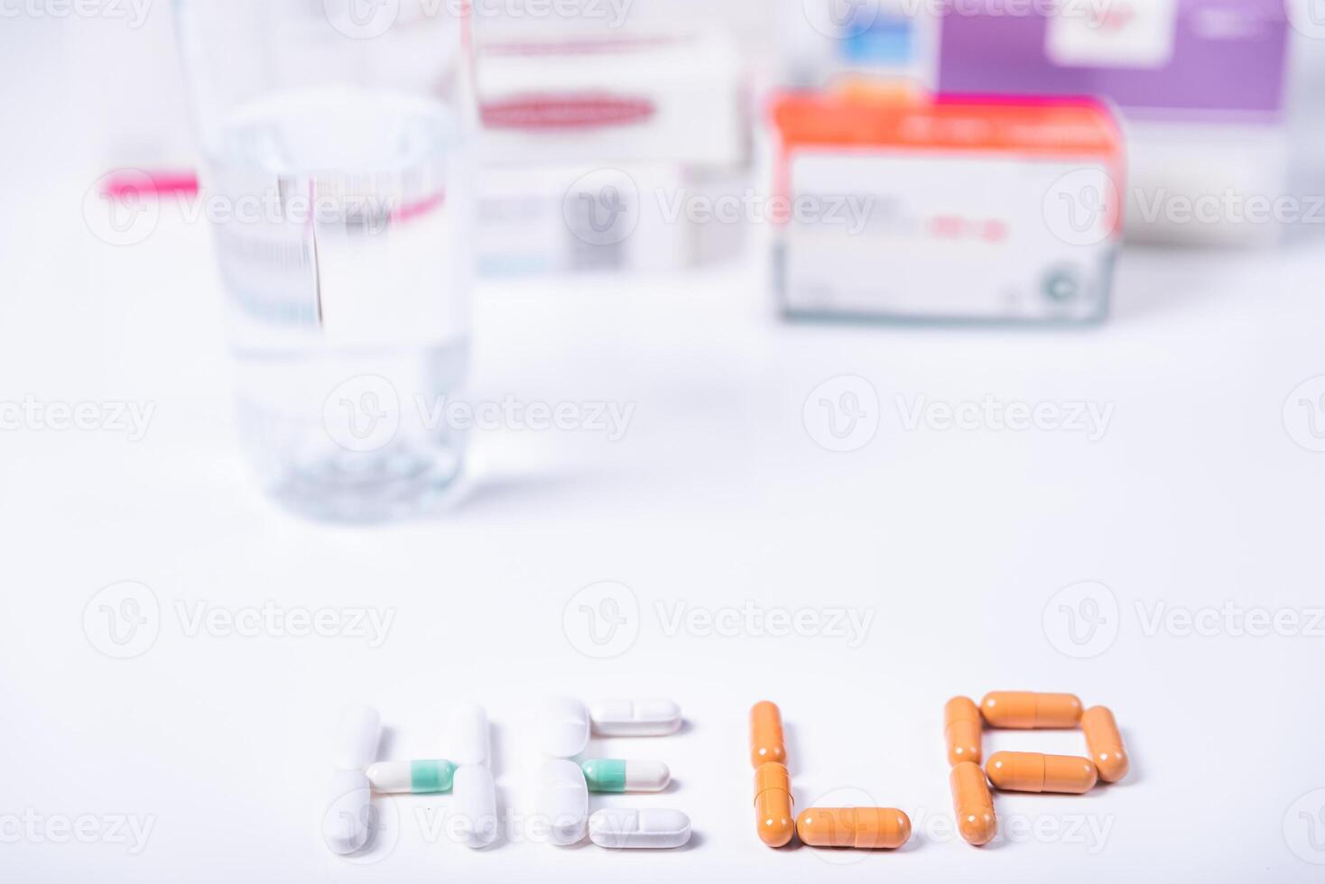 Word HELP made with medical pills and in the background several boxes of medicines. photo